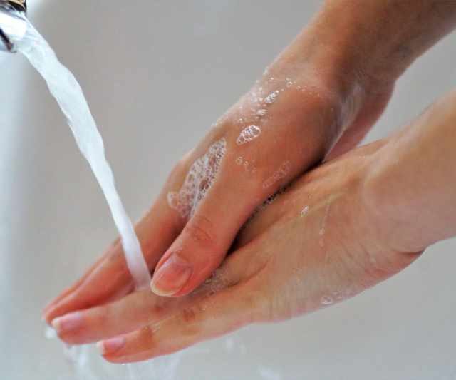Person washing their hands under running water
