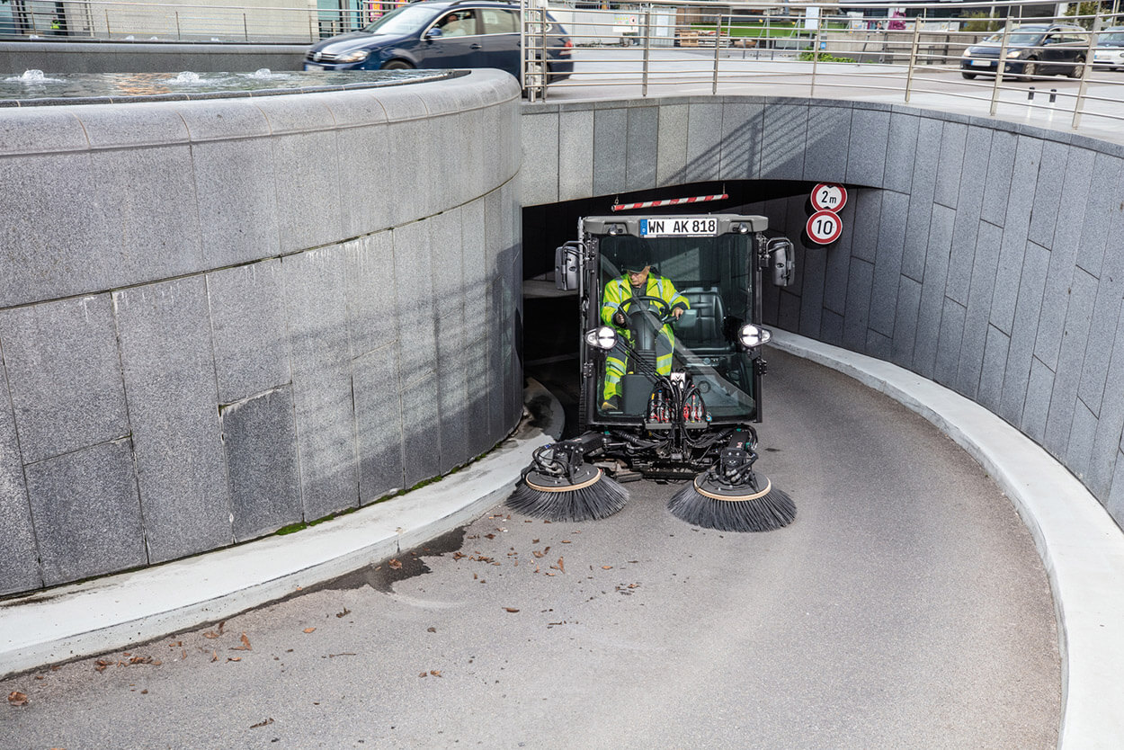 A man using a MC 250 road sweeper, clearing a road